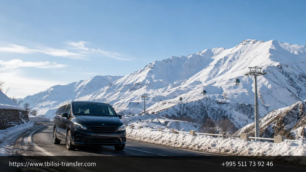 Snowy road to Gudauri — car on the mountain highway with the ski resort in the background